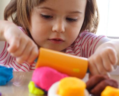 Montessori art corner where children explore colors and textures with paints and clay.