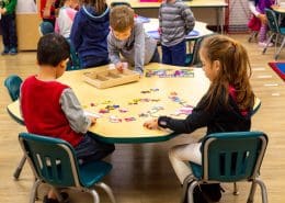 Students working independently with Montessori geography materials, learning about continents.