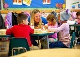 Students engaging in sensorial activities, using Montessori color tablets to match shades.